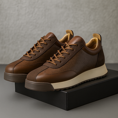 Brown leather sneakers with beige orthopedic soles on black box — angled front view